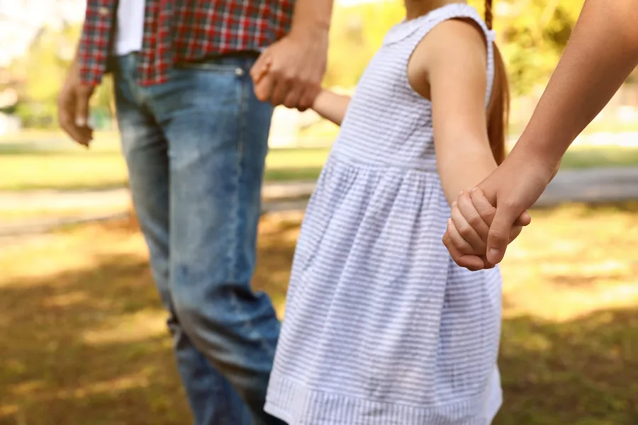 Parents holding hands with toddler