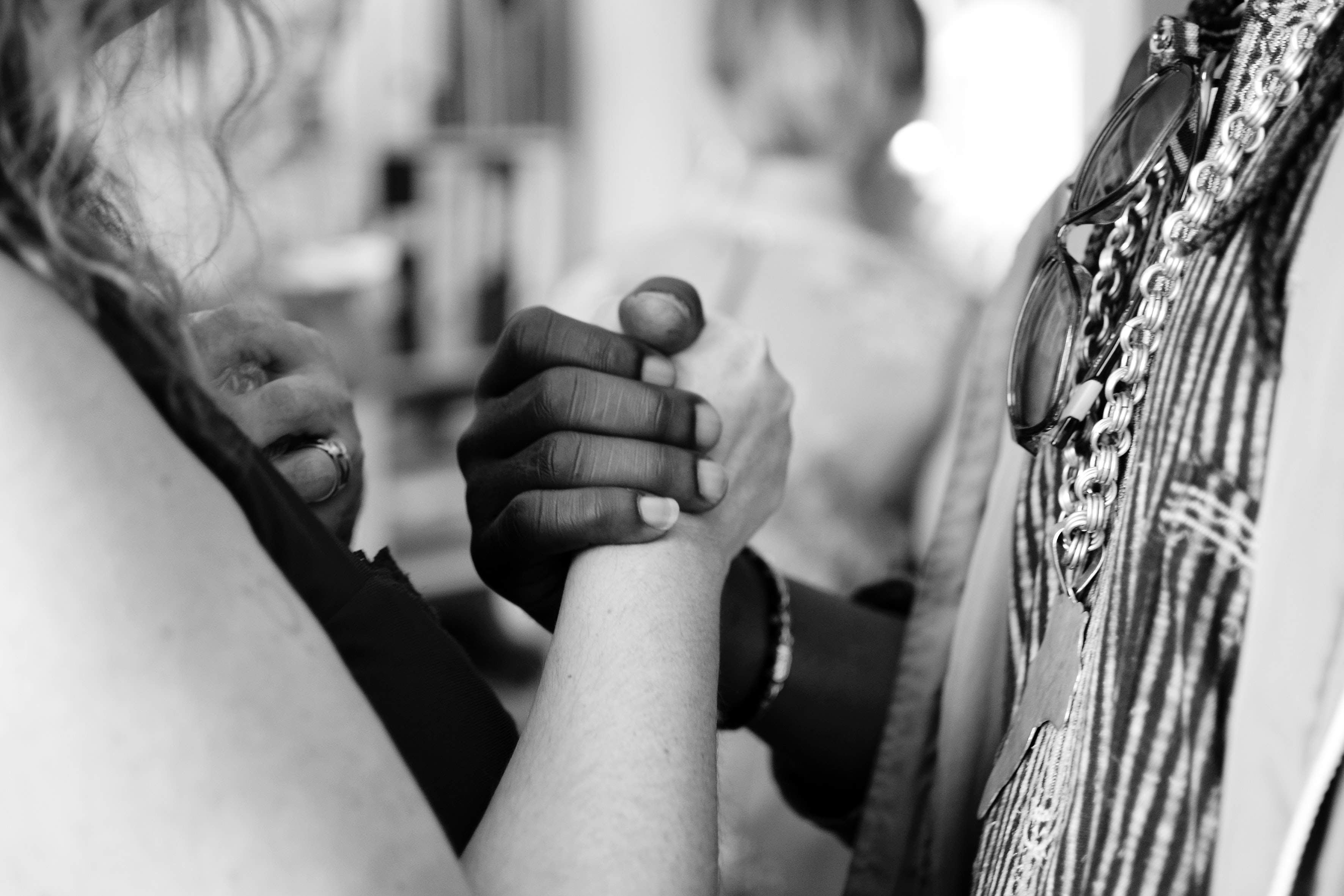 white person and black, holding hands communicating joining together