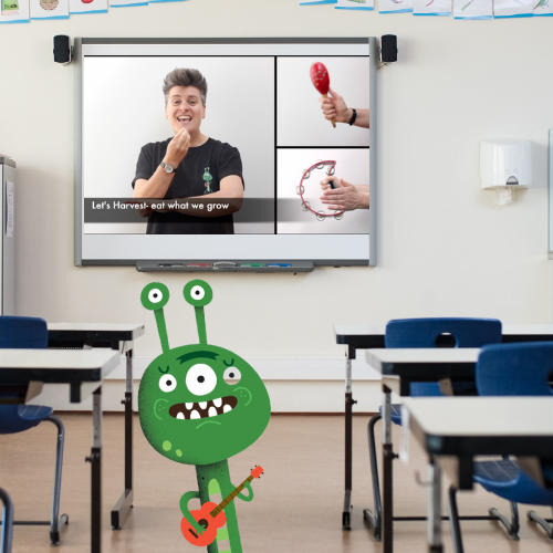 Image shows smartboard in classroom with AL Start from Go Kid Music on screen and little green alien in foreground